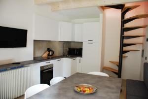 a kitchen with a table with a bowl of fruit on it at La casa del borgo in Dervio