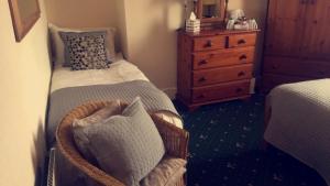 a small bedroom with a bed and a dresser at The Bay Guest House in Weymouth