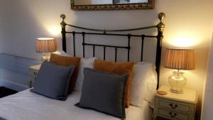 a bedroom with a bed with pillows and two lamps at The Bay Guest House in Weymouth
