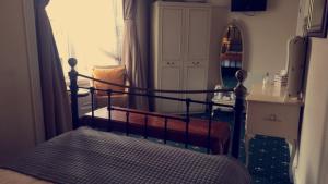 a bedroom with a bed and a table and a chair at The Bay Guest House in Weymouth