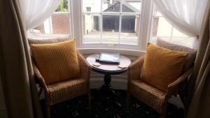 a room with two chairs and a table and a window at The Bay Guest House in Weymouth