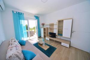 - un salon avec un canapé et une télévision dans l'établissement Apartments Garden Residence, à Opatija