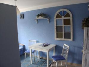a table and chairs in a room with a blue wall at K 2 in Jastrzębia Góra