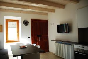 a living room with a table and a tv on the wall at La casa del borgo in Dervio