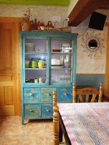 une armoire bleue avec de la vaisselle dessus dans une cuisine dans l'établissement Casa Rural Lamadretierra, à Villamejil