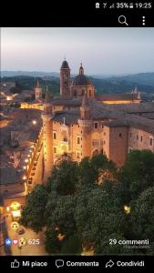 a large building with a clock tower at night at La Contessa (Da Fabiola) in Urbino
