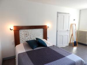 a bedroom with a bed with a wooden headboard and a door at Les sarmentins in Saint-Romain-sur-Cher