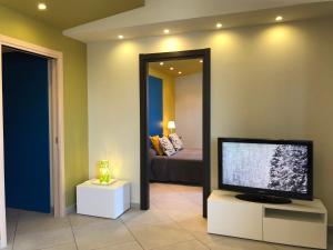 uma sala de estar com uma televisão de ecrã plano e uma cama em Terra di Sicilia em Avola