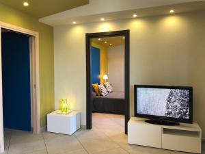 a living room with a flat screen tv and a bed at Terra di Sicilia in Avola