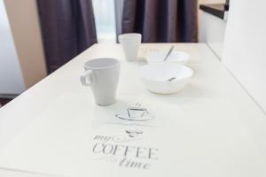 a white counter with cups and bowls on it at Naja's apartments (apartment 1) in Koper