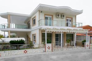 a large white house with a balcony on top of it at Villa Elsa in Skala Rachoniou +6 photos