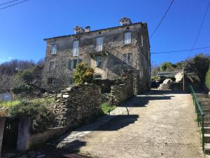 an old stone building on the side of a road at Chambres A Casa De Giovanni à Pietra-di-Verde en Haute-Corse in Pietra-di-Verde
