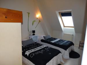 2 camas en una habitación pequeña con ventana en Gîtes de la Ferme Auberge de Mésauboin, en Billé