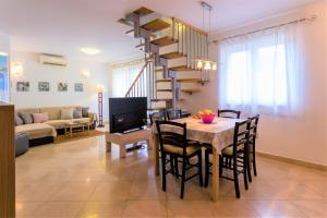a dining room and living room with a table and a spiral staircase at Apartments Viva in Korčula