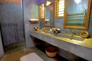 a bathroom with a sink and a mirror at L'heure Bleue in Ambatoloaka
