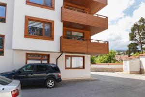 ein Haus mit einem davor geparkt in der Unterkunft Апартамент "Forest view" в комплекс "Вели Хилс" in Welingrad