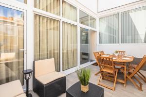 a screened porch with a table and chairs at Camarinha Oporto Apartments in Porto