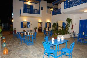 a restaurant with blue tables and blue chairs at Karabo Hotel in Livadi Astypalaias