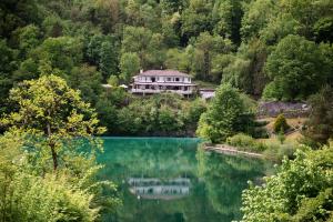 una casa su una collina vicino a un lago di Penzion Šterk a Most na Soči (Santa Lucia d'Isonzo)