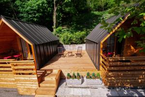 a house with a black roof and a wooden deck at Penzion Šterk in Most na Soči