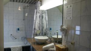 a bathroom with two sinks and a large mirror at De Basiliek in Edegem