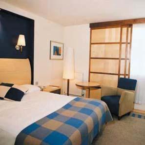 Habitación de hotel con cama y silla en Roebuck Inn en Stevenage