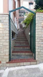 a set of stairs with a green gate and a stair case at Green Hill Studios & Apartments in Kokkari