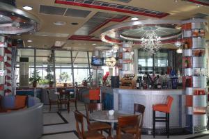 un ristorante con bar, tavoli e sedie di Hotel Bar Restaurant America a Kukës