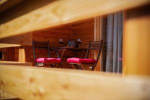 two chairs with red cushions sitting in front of a table at Penzion Šterk in Most na Soči