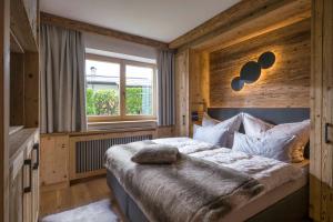 ein Schlafzimmer mit einem großen Bett und einem Fenster in der Unterkunft Landhaus BergMoment - adults only in Ellmau