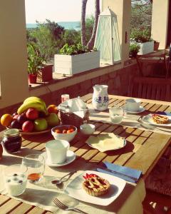 una mesa de madera con comida y fruta. en Mirto E Mare, en Muravera