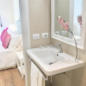 a white bathroom with a sink and a mirror at Flowers Sweet Rooms B&B in Vasto
