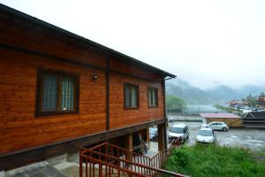 a wooden house with cars parked in a parking lot at Kuloğlu Apart 2 in Uzungöl