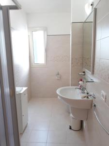 a white bathroom with a sink and a mirror at Residence Maresol in Vieste