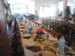 a long table with plates of food on it at Agriturismo la Mimosa in Putzu Idu +27 photos