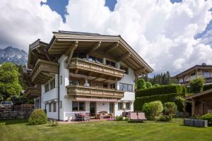 a large white house with wooden balconies at Landhaus BergMoment - adults only in Ellmau