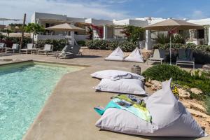 a row of pillows sitting next to a swimming pool at Portes Houses in Koufonisia