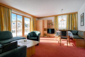 Habitación de hotel con sala de estar y comedor. en Haus Kaschutnig, en Fiss