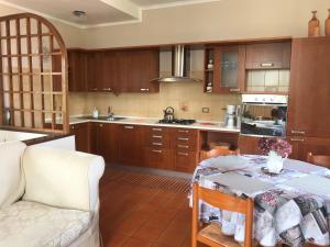 a kitchen with wooden cabinets and a table with at Le Betulle in Oggebbio