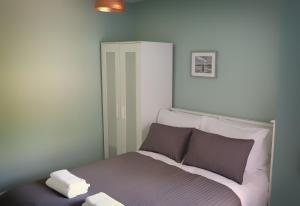 um quarto com uma cama com duas almofadas em Conwy Cottage em Conwy