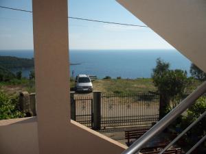 a van parked on a fence with the ocean in the background at Apartments Safija in Dobra Voda