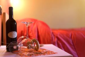 una botella de vino y una copa de vino en una mesa en B&B Il Nido, en SantʼAntìoco