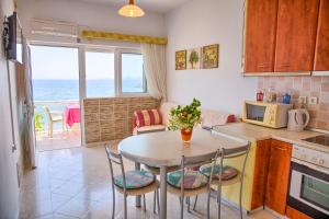 a kitchen with a table and chairs and a kitchen with the ocean at Chara's Sea View House in Haraki