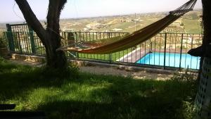 a hammock hanging from a tree next to a pool at Le Case Del Vivaio in Sciacca