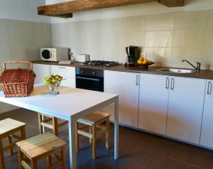 a kitchen with white cabinets and a table and chairs at House in the Town Centre in Caminha