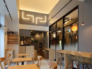 a restaurant with wooden tables and chairs at APA Hotel Shin Osaka Ekiminami in Osaka