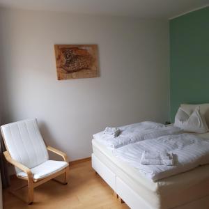 ヴァーネミュンデにあるTwee Linden Warnemünde Zentrumのベッドルーム(白いベッド1台、椅子付)