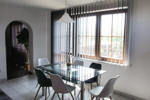 a dining room with a glass table and chairs at Apartmány City in Ostrava
