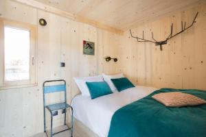 a bedroom with two beds and a chair in it at Les Lodges, by Refuges en ville in Bourg-Saint-Maurice