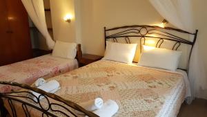 a bedroom with two beds with white towels on them at Castello Bellos studios in Keri